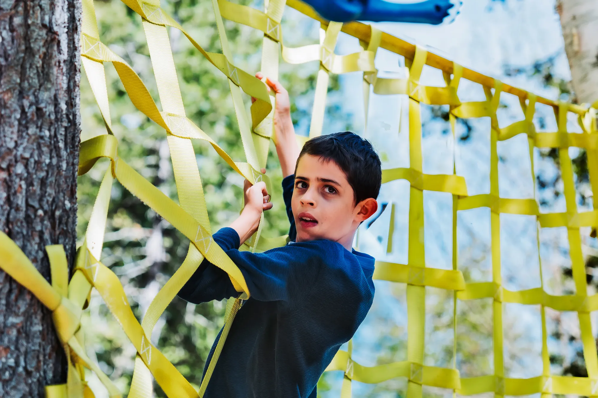 Child climbing the cargo net on the Warrior Confidence Course