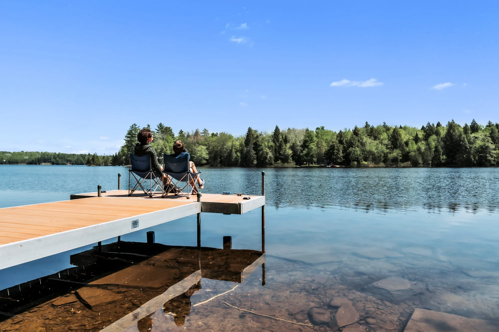 Guests seated on the Dragonwood dock overlooking the pond