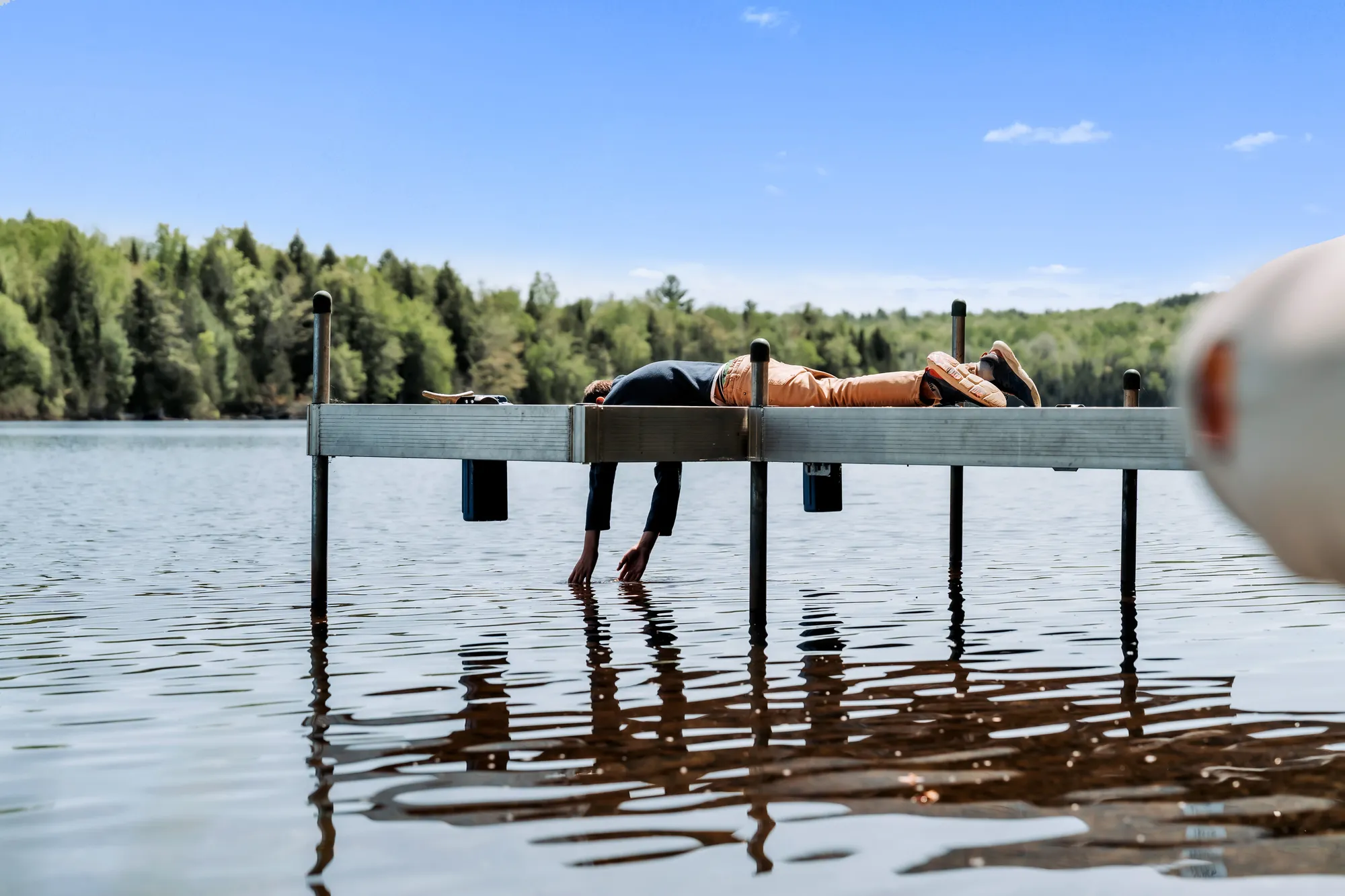 Guests touching the water from the dock on Manhanock Pond